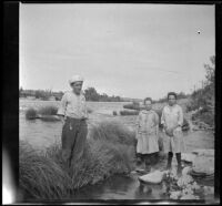 William "Babe" Bystle and Frances and Elizabeth West stand in the Sacramento River, Redding vicinity, about 1914