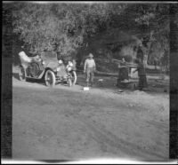 Dave F. Smith, Nella A. West and Isabelle Smith standing in their campsite near the American River, Eldorado National Forest, 1913