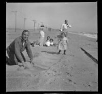 H. H. West's family sits and stands in the sand, Venice, about 1908