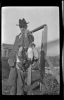 Chet Edgell poses with ducks from a shoot, Seal Beach vicinity, 1916