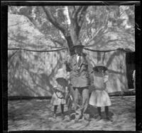 Frances West, H. H. West and Elizabeth West pose in front of a cluster of tents, Santa Catalina Island, about 1910