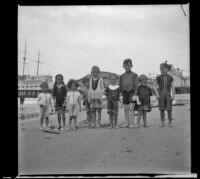 Elizabeth West, Edmond Mead, Frances West and Paul Mead pose with other children on the beach in front of Venice pier, Venice, about 1910