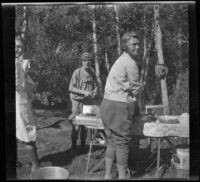 Mertie West, Edith Shaw, and Agnes Whitaker stand around a table at Convict Lake, Mammoth Lakes vicinity, 1929