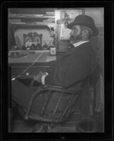 Frank E. Prior sitting at his desk at the Arcade depot (negative), Los Angeles, about 1900