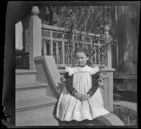 Josephine Lacy sits on the front porch steps of the Lacy family home, Los Angeles, about 1900