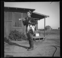 Carl Salbach stands holding a gun and ducks killed during a hunt, Orange County vicinity, 1912