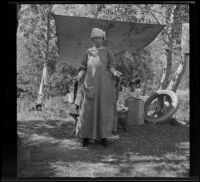 Mary A. West posing with a couple of fish in camp, June Lake vicinity, 1914