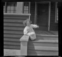 Frances West sits at the top of the stairs in front of the West's beach cottage, Venice, about 1907