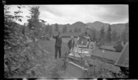 W. L. Kinsell, Mertie West and Frances Wells visit the spirit houses in Eklutna Historical Park, Eklutna, 1946