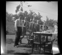 Everett Shaw, Hebard West, Lester Shaw, H. H. West, Will Shaw, J. W. McDonald and Chloe McDonald pose around a picnic table in the McDonalds' backyard, Burbank, 1948