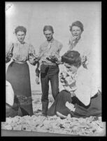Agnes Hawley, John Ramboz and 2 other women pose while eating on the beach, Santa Catalina Island, about 1900