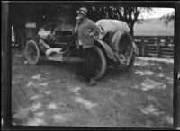 Bessie Velzy standing beside the Velzy's Buick and having a snack, Mendocino County vicinity, 1915