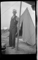 Abraham Whitaker standing in front of a tent near Rincon Point, Carpinteria vicinity, about 1924