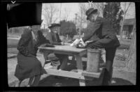 Mertie West, Zetta Witherby and Wes Witherby at a picnic table, eating lunch at Lake Mead, Boulder City vicinity, 1939