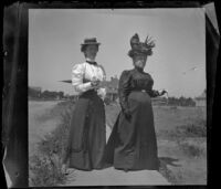 Minnie Kellum and Lucretia Kellum stand on a sidewalk in their neighborhood, Los Angeles, about 1899