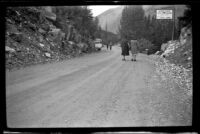 Mertie West and another woman stand on the road at Kicking Horse Tea Room, Field vicinity, 1947