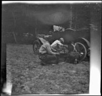 Wilfrid Cline, Jr. and two others fixing the tire on Ade Bystle's Ford, Trinity County, 1917