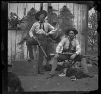 H. H. West and Bim Smith posing with their guns in front of animal pelts, Pomona, about 1895