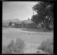 Elizabeth West standing in front of H. H. West's Buick outside the old Freeman station, Kern County, 1914