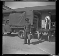 H. H. West Jr. holds his luggage at the Southern Pacific Railroad depot, San Luis Obispo, 1942