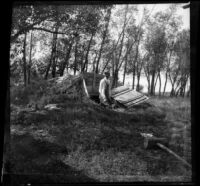 William Mead emerges from a cellar on the Mead's property, Elliott vicinity, 1900