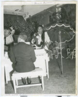 Actress Louise Beavers at the microphone at a backyard event, Los Angeles, 1940s