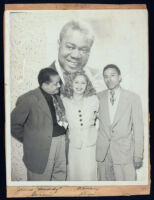 James "Buddy" Garcia and Alyce Key in front of a poster of Louis Armstrong, Los Angeles, 1940s