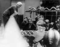 Mantle Hood and eight instrumentalists in rehearsal