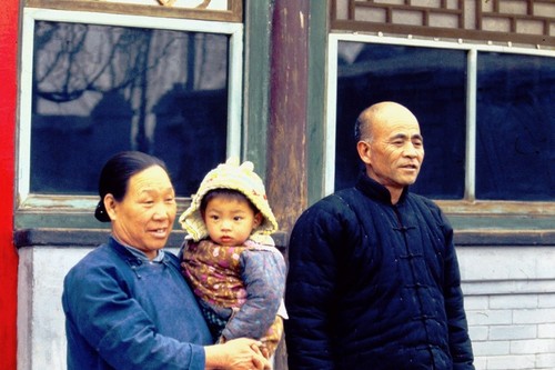 Traditional courtyard house in old Beijing, grandparents with grandchild