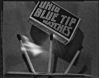 Three matches burning beneath a box of Ohio Blue Tip Matches, 1925-1939