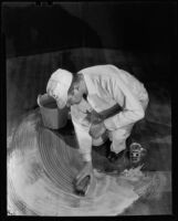 Workman cleaning a floor with "Double X Floor Cleaner," circa 1934