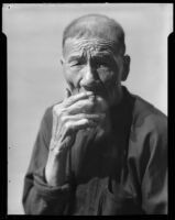 Asian-looking man, probably in Will Connell's photography studio, 1930-1960