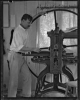Arthur Millier operating a rolling press, Santa Monica, 1930