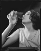 Photograph of a woman drinking a glass of Arrowhead Spring Water, Los Angeles, 1935