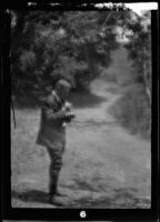 Will Connell (possibly) in rural setting standing next to a dirt road, circa 1920