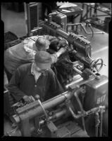 Two National Auto Shop technicians working at machinery, 1930-1950