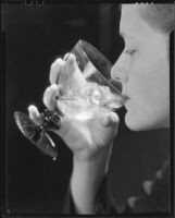 Woman drinking a glass of ice water, 1930-1937
