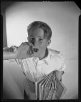 Newspaper boy hawking his wares for an advertisement, 1925-1939