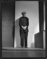 Asian-looking man standing, probably in Will Connell's photography studio, 1930-1960