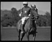 Raymond Griffith on his polo horse with his mallet raised, Los Angeles, 1931
