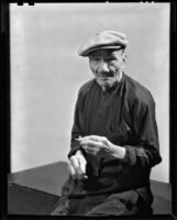 Asian-looking man seated, probably in Will Connell's photography studio, 1930-1960