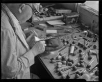 Technician engraving the bell of a brass horn at the F. E. Olds and Son plant, Los Angeles, between 1933-1939