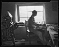 Walter Willard "Spud" Johnson seated next to his hand press, Santa Fe or Taos, 1932