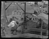 Three men working with gas regulator equipment in an oil field, California, circa 1931