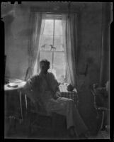 Walter Willard "Spud" Johnson seated next to his hand press, Santa Fe or Taos, 1932