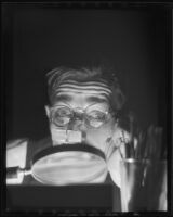 Man looking through a hand lens, 1930-1960