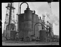Storage tanks and derricks in an oil field, California, circa 1931