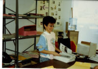 Connexxus office: Woman with stack of newsletters