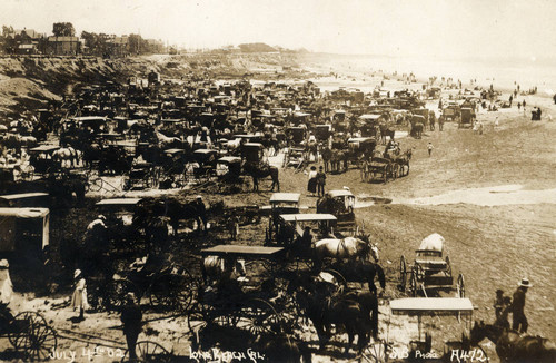 Beach crowded with carriages and people