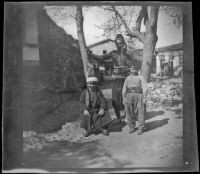 Man and two boys in front of a house, Turkey, 1895